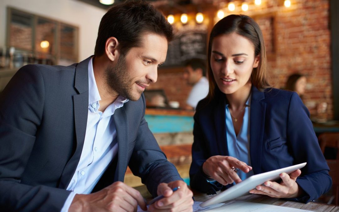 man and woman in a coffee shop discussing sales pipeline management